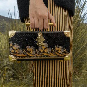 Detalle bolso minimalista de madera pintado a mano con motivos florales hindúes dorados