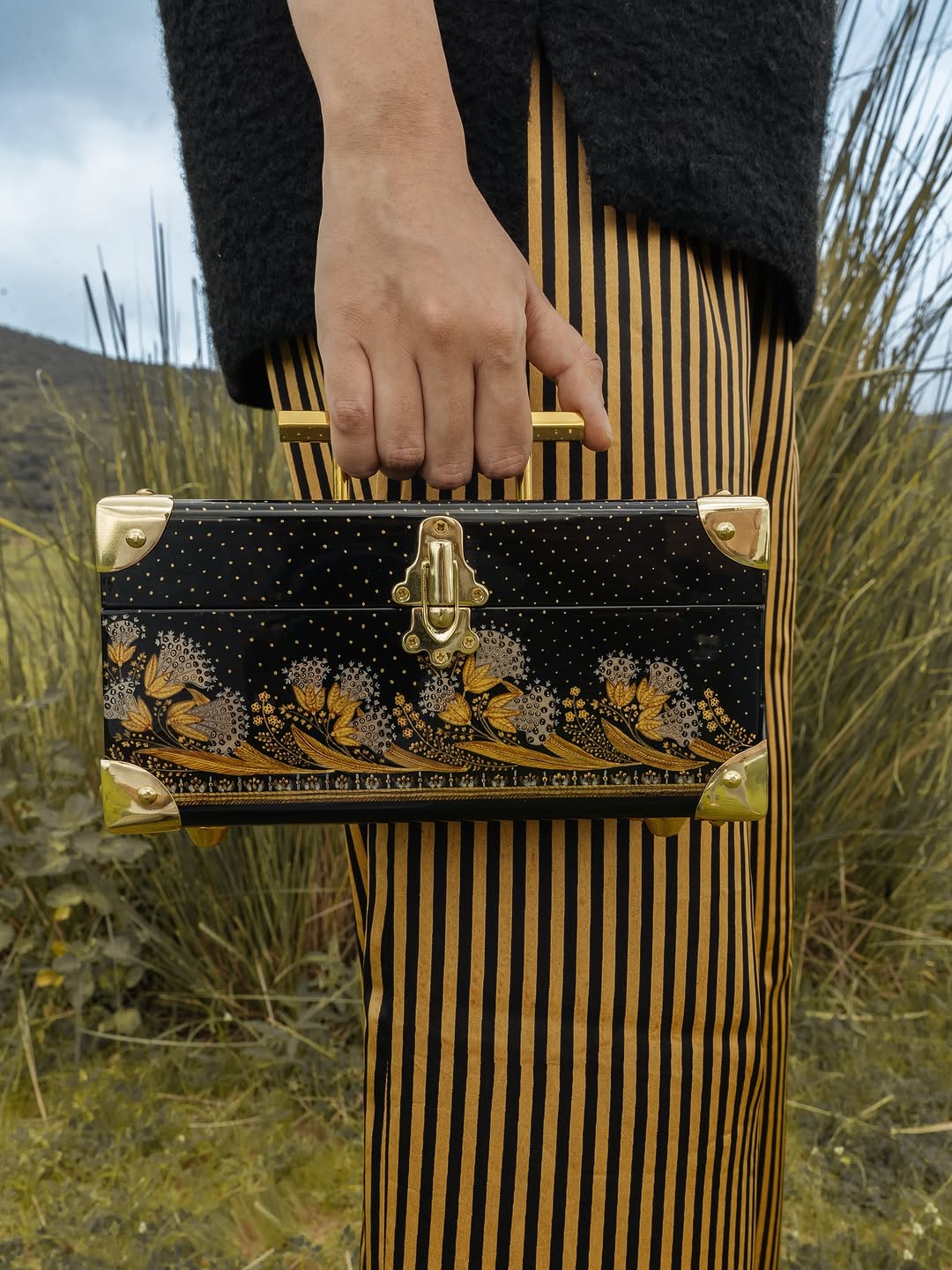 Detalle bolso minimalista de madera pintado a mano con motivos florales hindúes dorados Detalle bolso minimalista de madera pintado a mano con motivos florales hindúes dorados