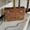 Bolso artesanal de madera decorado con motivos florales y animales, abierto mostrando interior verde y herrajes dorados.
