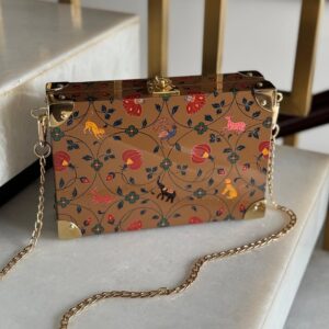 Bolso artesanal de madera decorado con motivos florales y animales, abierto mostrando interior verde y herrajes dorados.