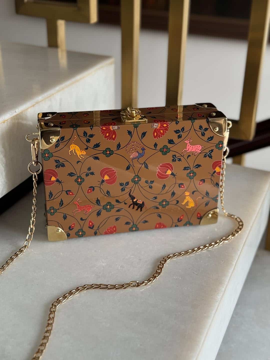 Bolso artesanal de madera decorado con motivos florales y animales, abierto mostrando interior verde y herrajes dorados. Bolso artesanal de madera decorado con motivos florales y animales, abierto mostrando interior verde y herrajes dorados.